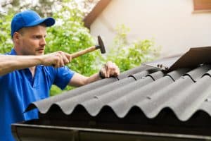 Roofer installing bitumen roof sheets